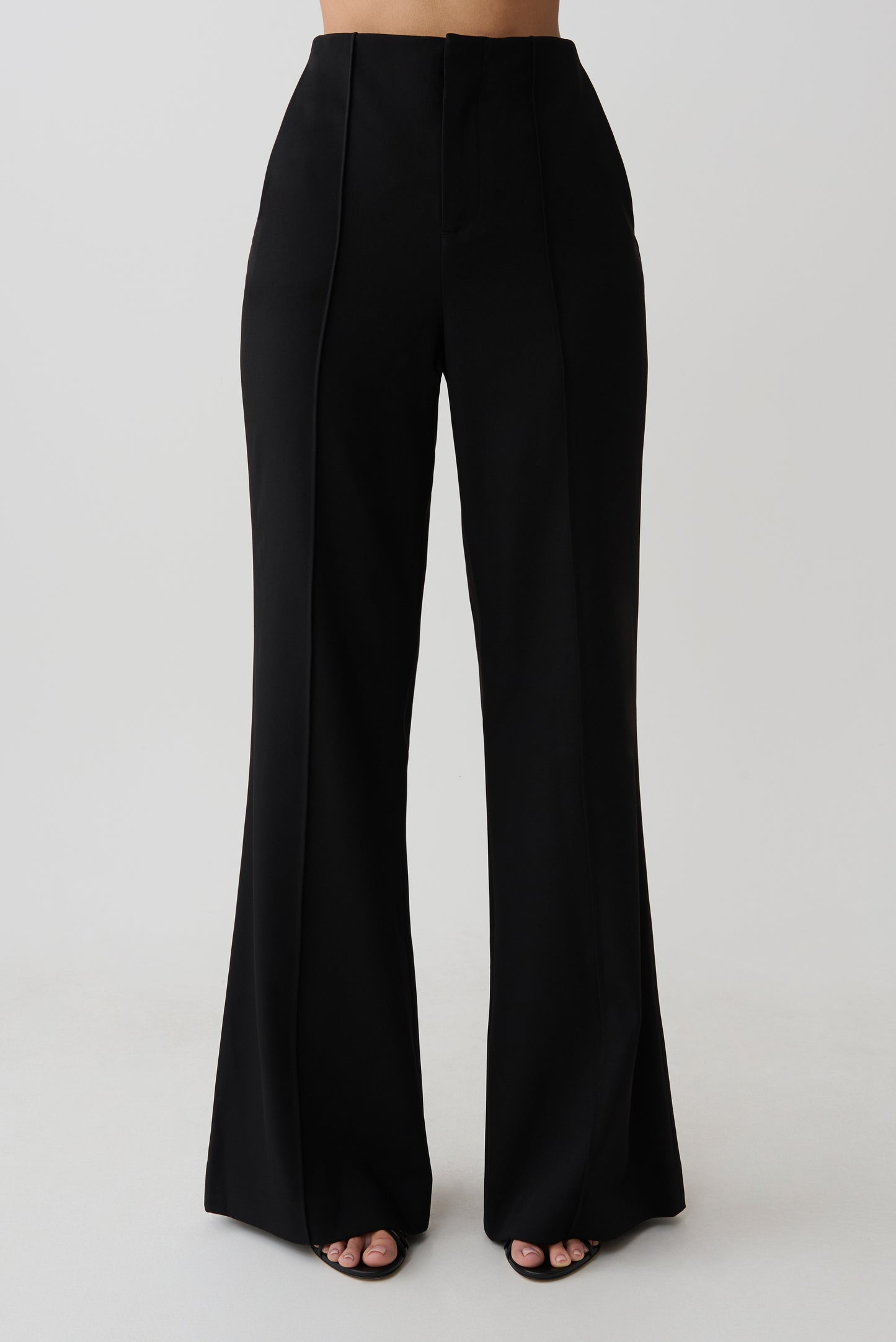 Woman wearing black high waisted suiting pants.