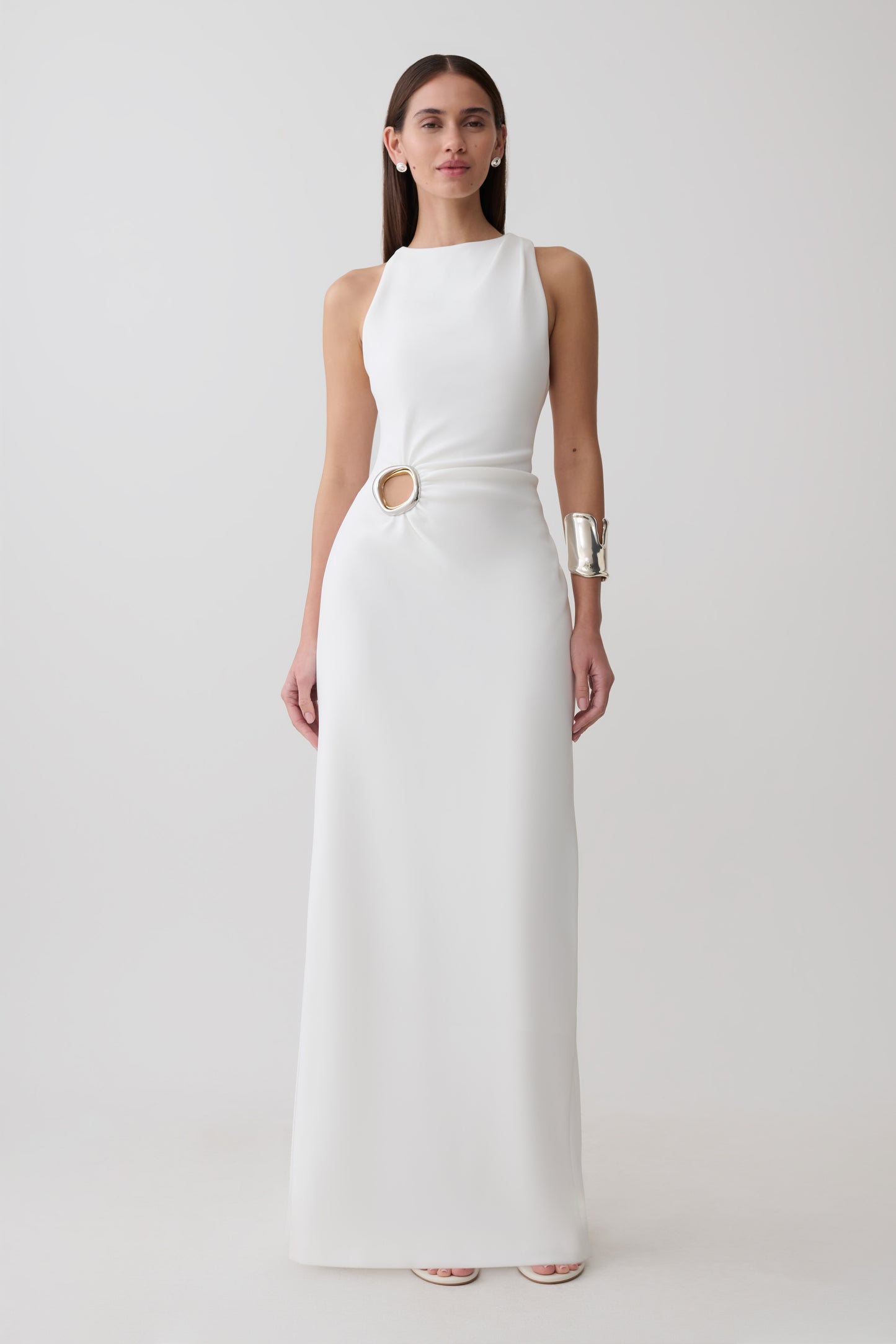 Woman wearing a white maxi dress wiith silver hardware.
