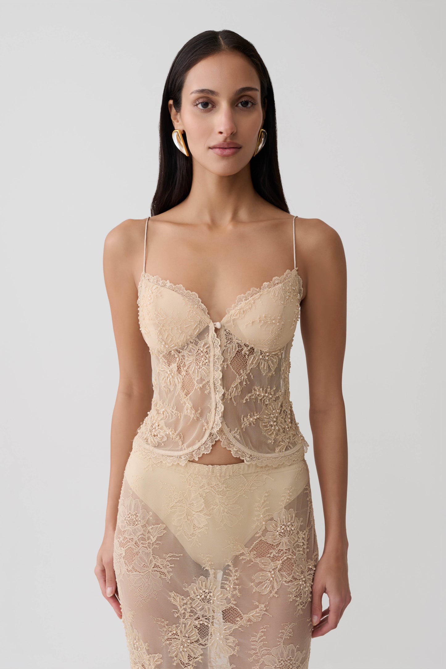 Woman wearing gold sweetheart lace top.