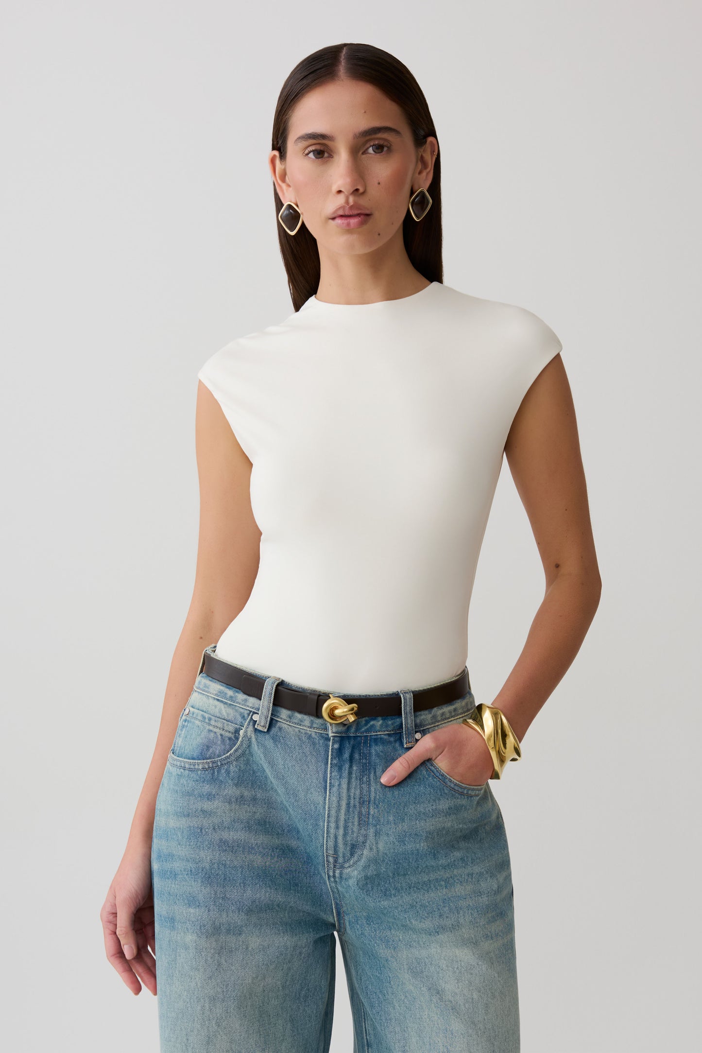 Woman wearing white peached jersey high neck top.