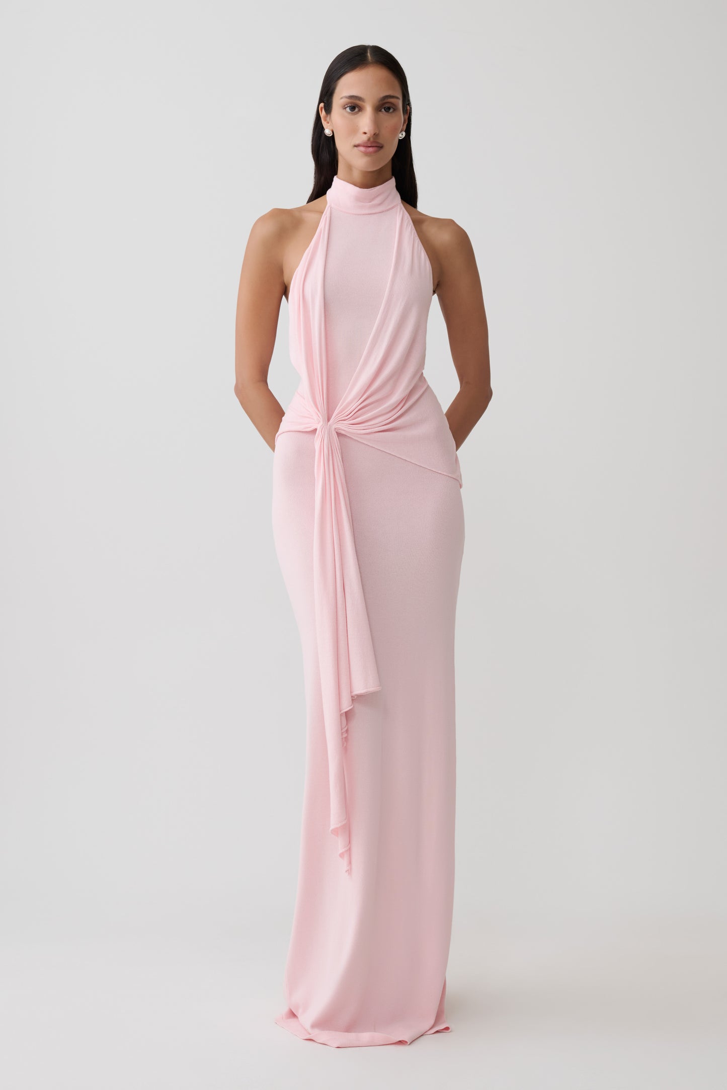 Woman wearing a pink halter knit maxi dress.