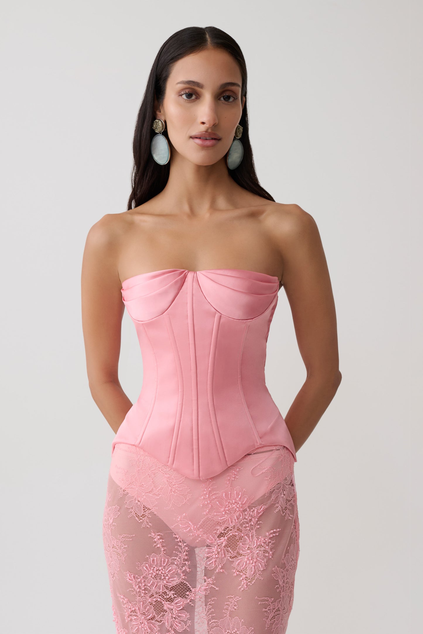 Woman wearing a pink satin strapless corset.