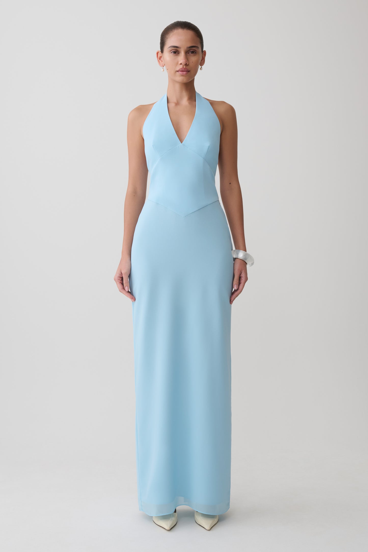 Woman wearing a light blue halter neck maxi dress.