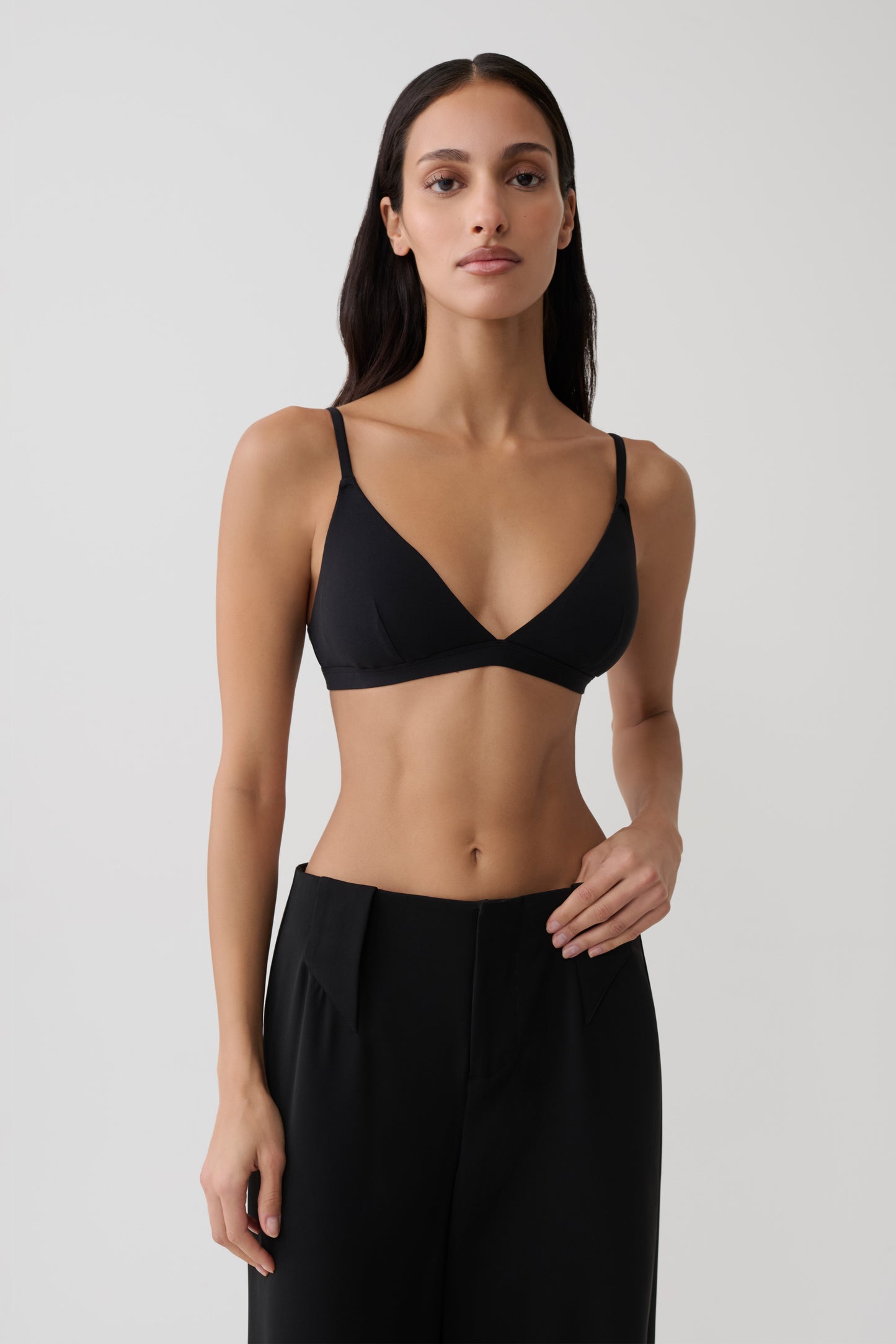 Woman wearing black micro triangle bralette.