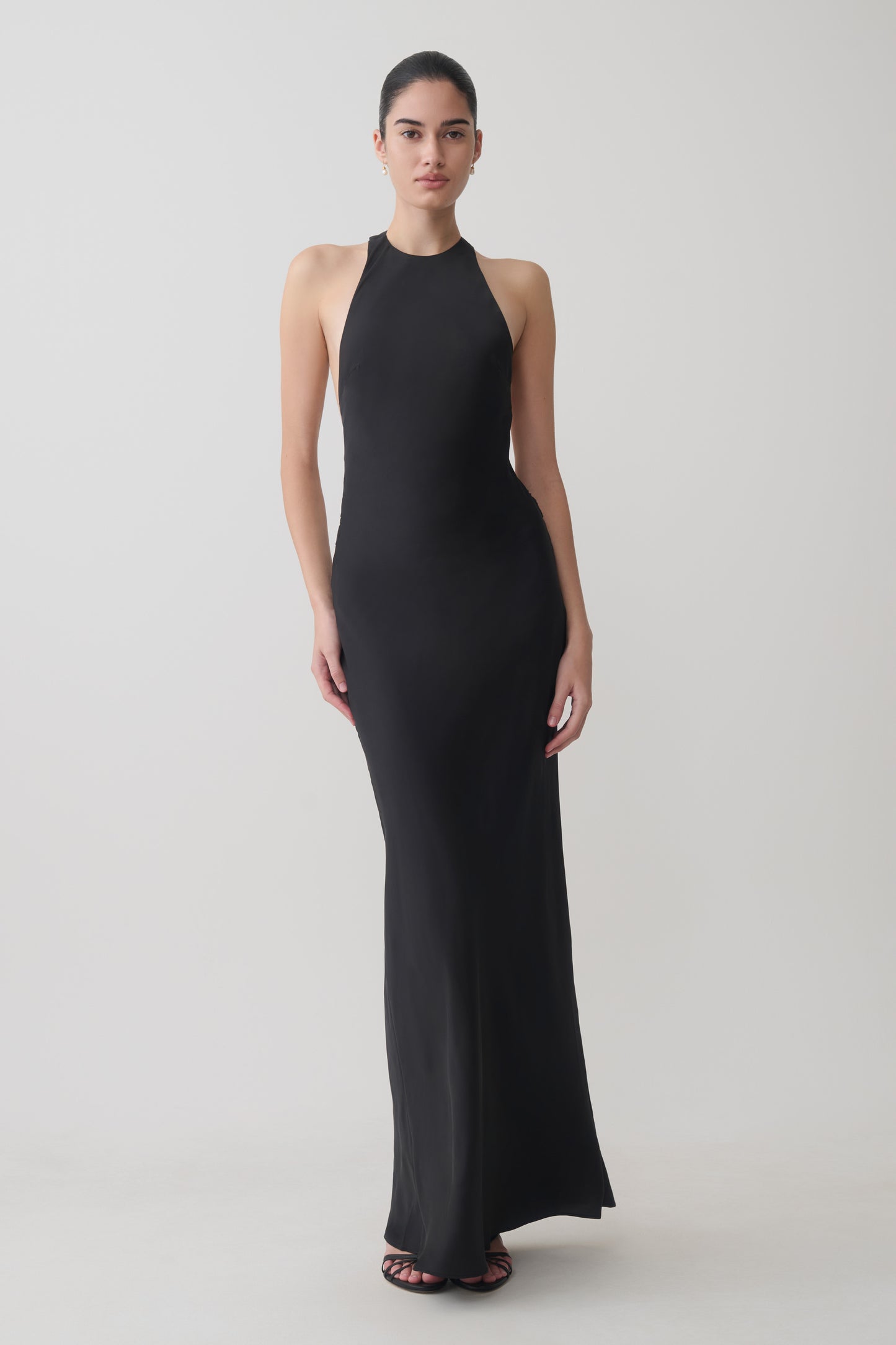 Woman wearing a black satin halter maxi dress.