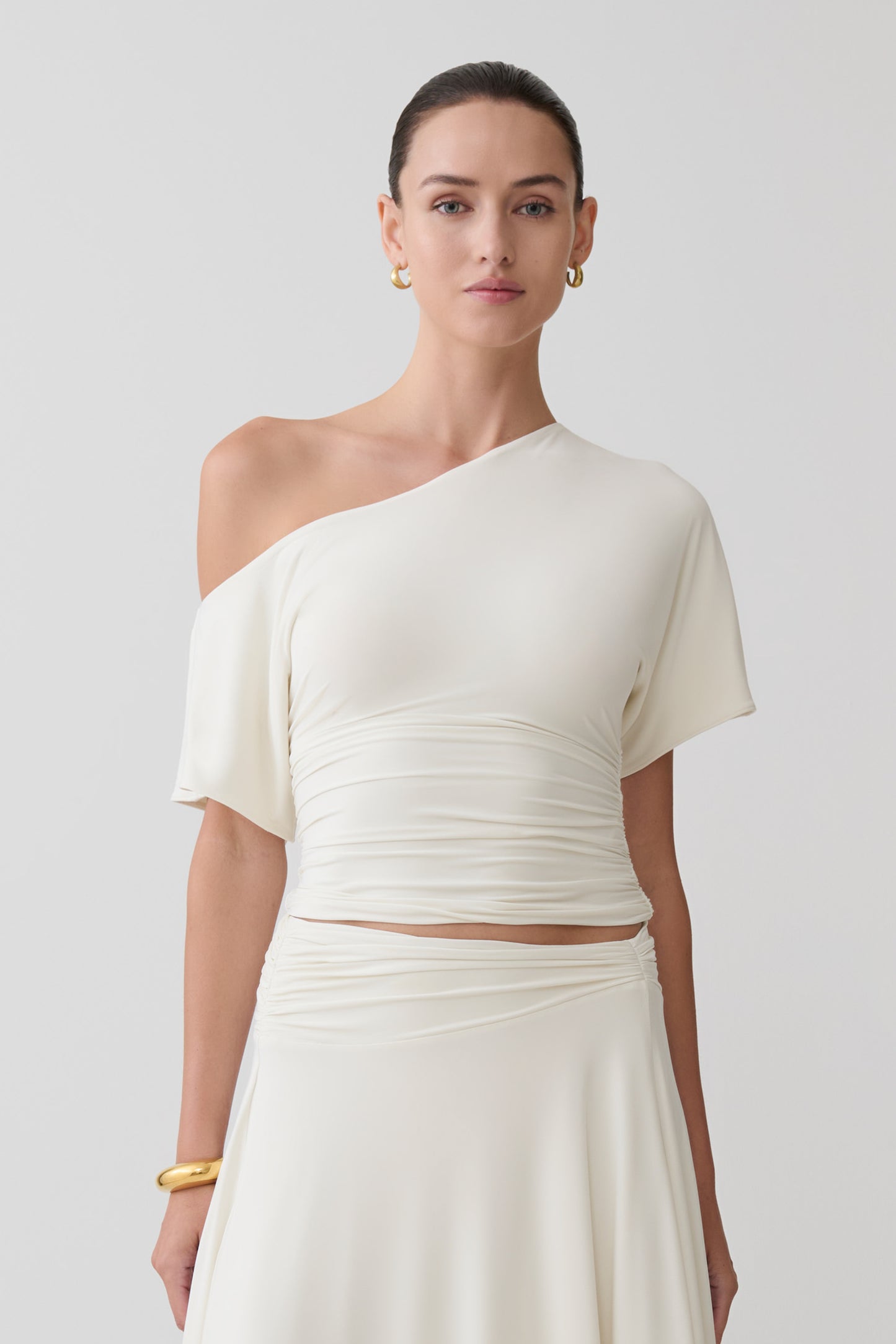 Woman wearing a white off-shoulder top.