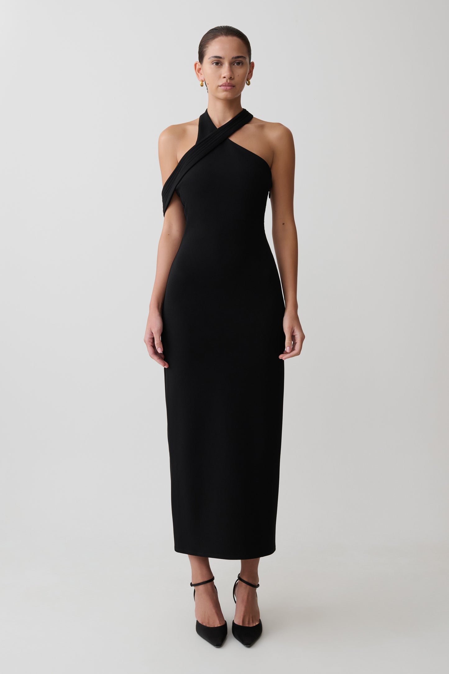 Woman wearing black crossover neck dress.