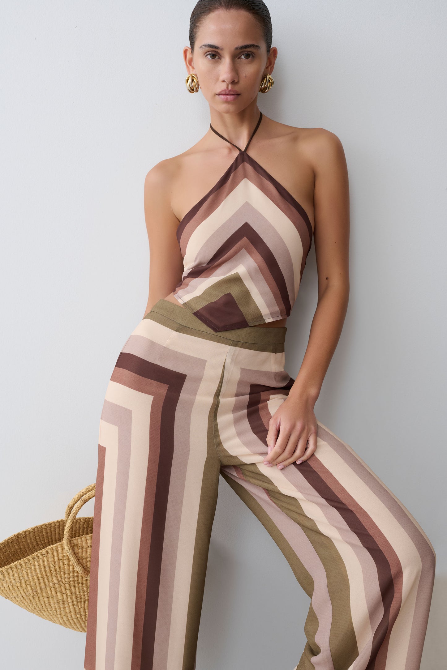 Woman wearing a striped jumpsuit against a plain background