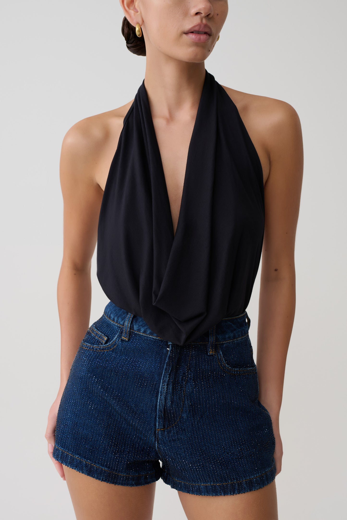 Person in black halterneck plunge top