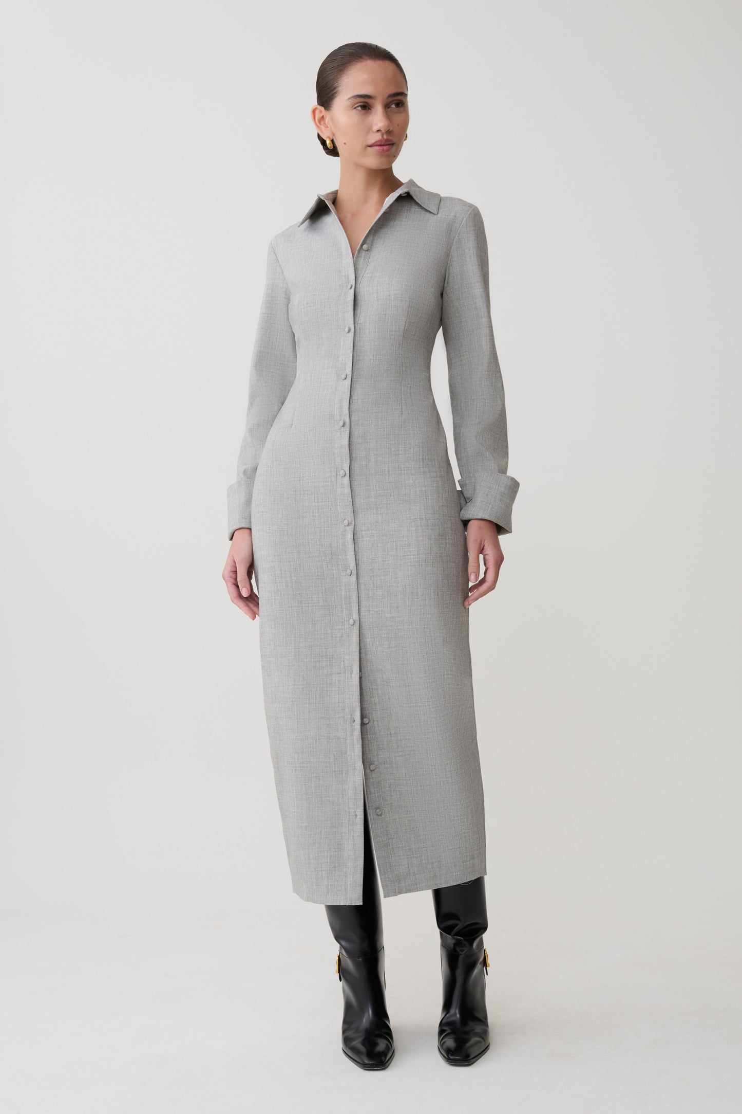 Woman wearing a long gray coat on a white background