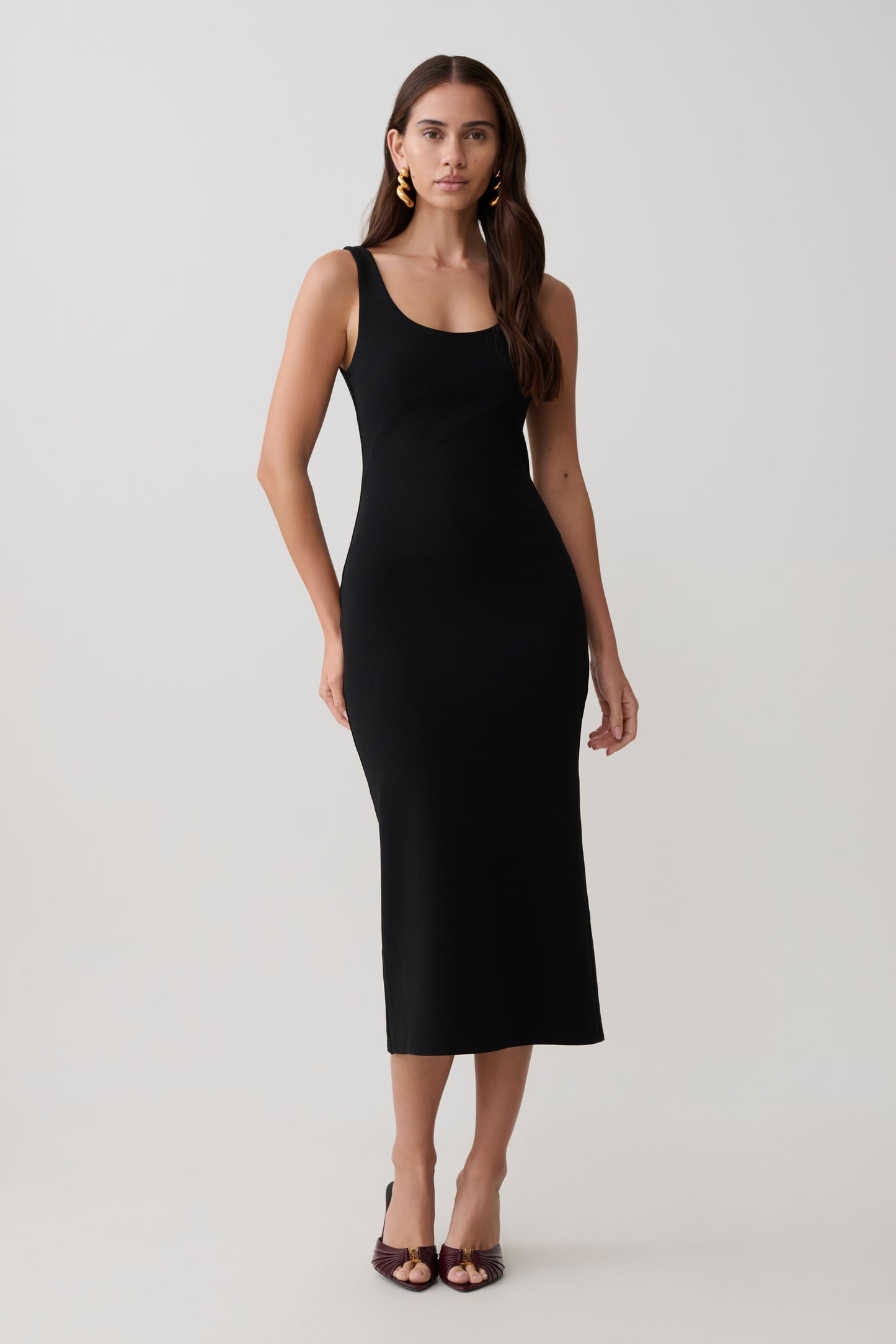 Woman wearing a black stretch crepe mini dress.