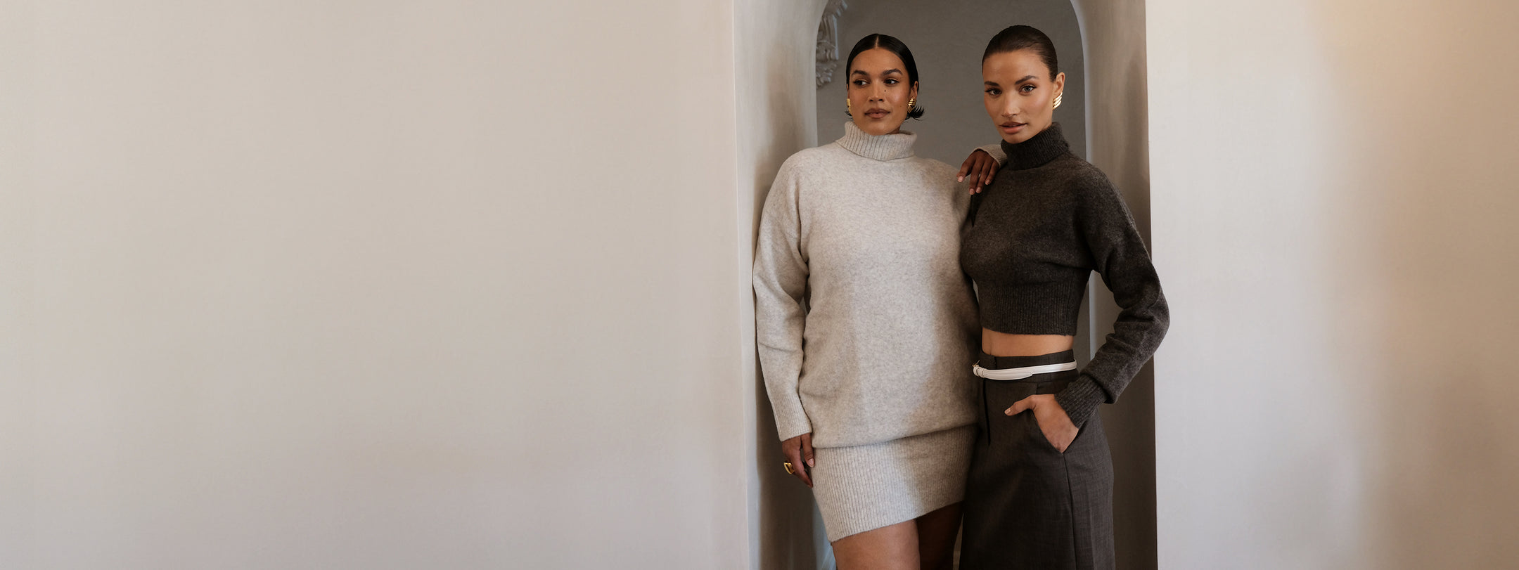 Image of women in grey knit dress and charcoal knit turtleneck.