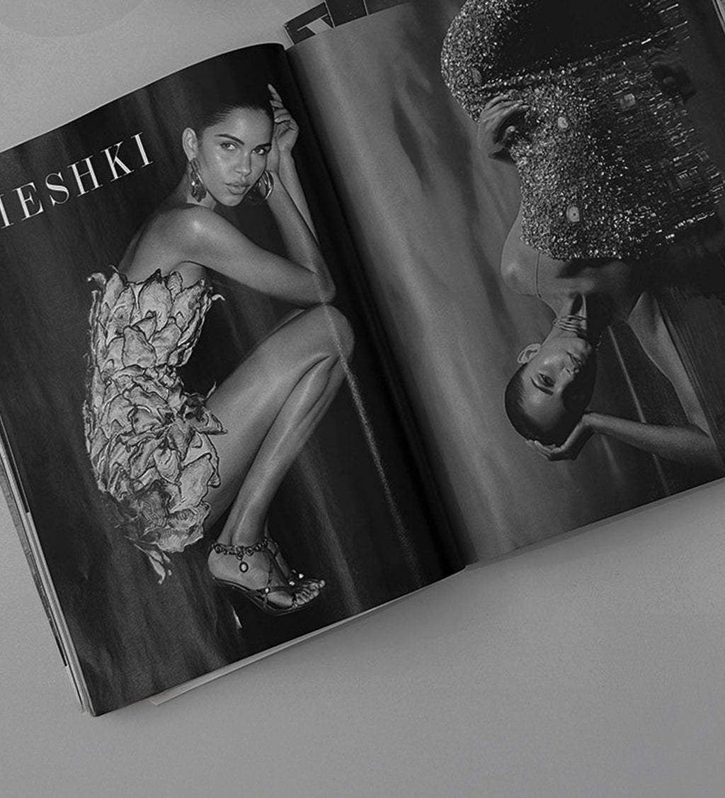 Open magazine showing a model in a floral dress MESHKI branding.