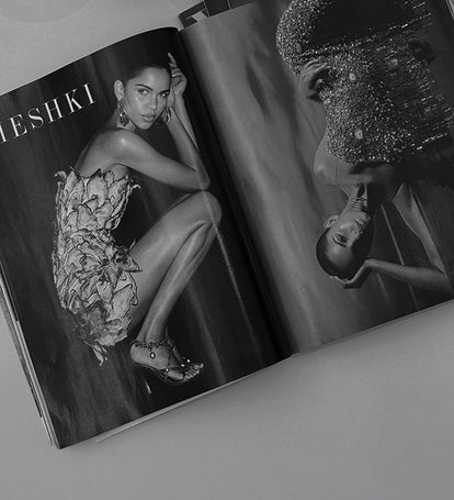 Open magazine showing a model in a floral dress MESHKI branding.