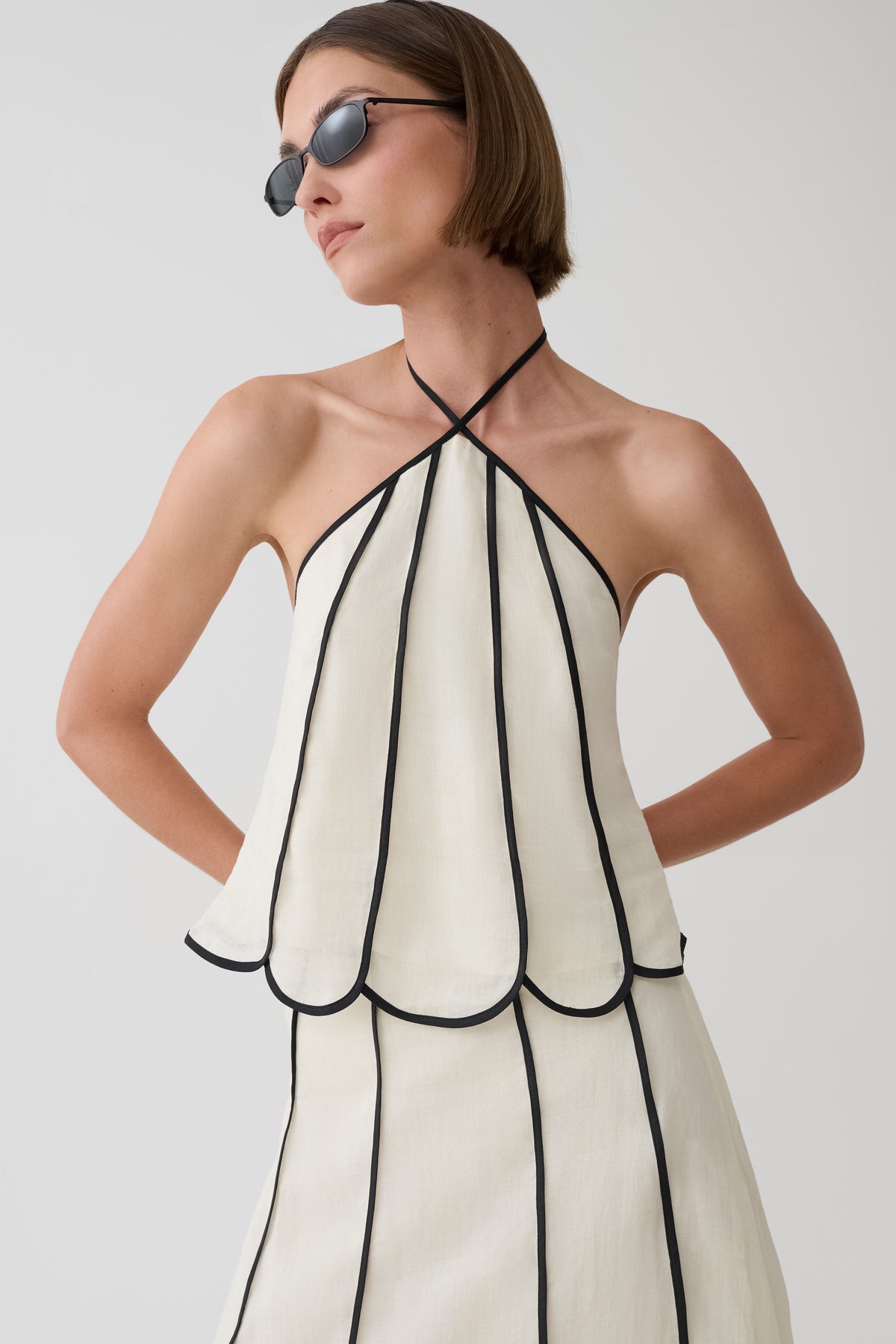 Woman wearing a black and white panelled halter sleeveless top.