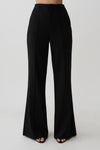 Woman wearing black high waisted suiting pants.