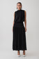 Woman wearing a black sleeveless drop waist gathered midaxi dress.