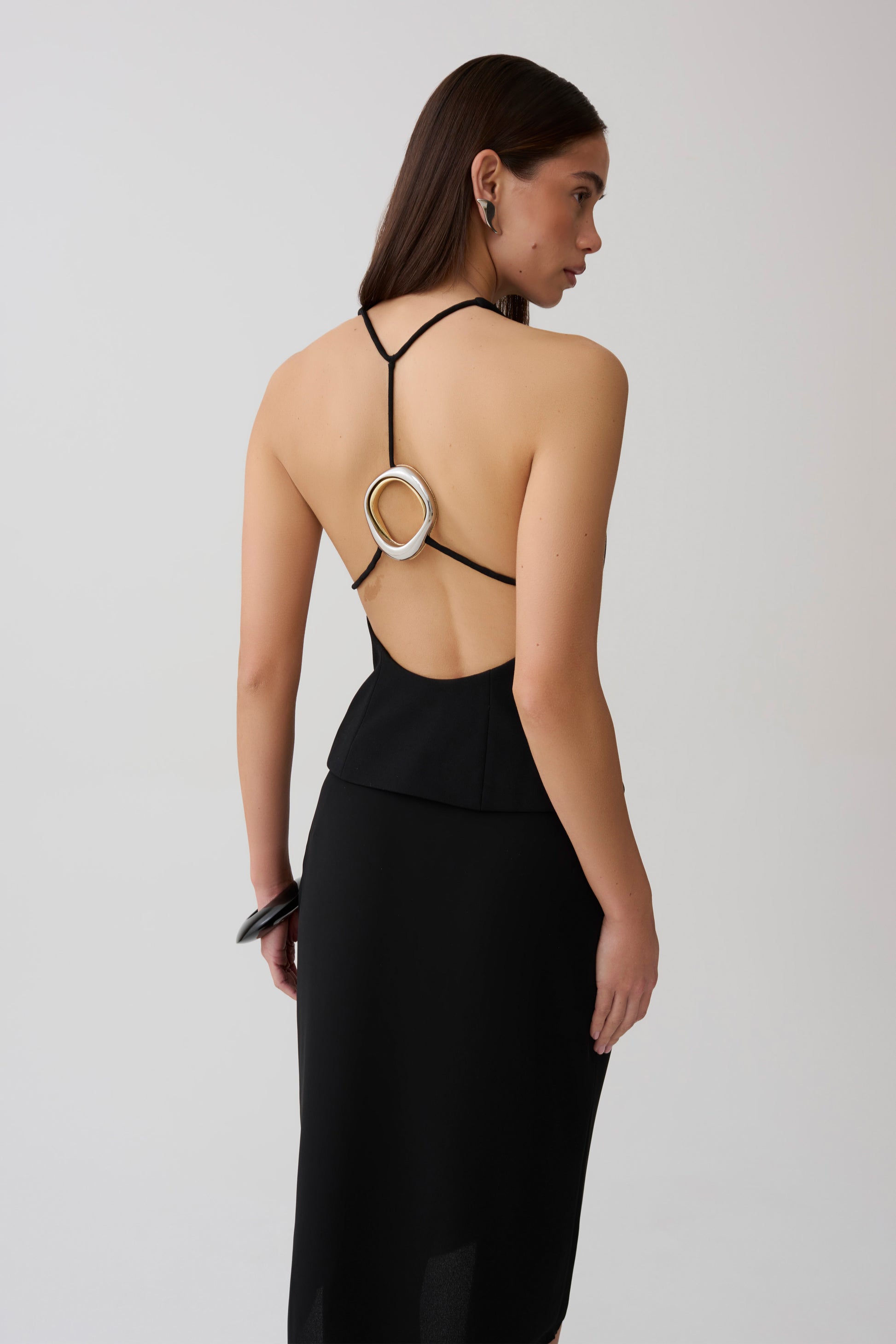 Woman wearing a sleeveless top with sliver hardware.