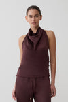 Woman wearing a brown satin halter sleeveless top.