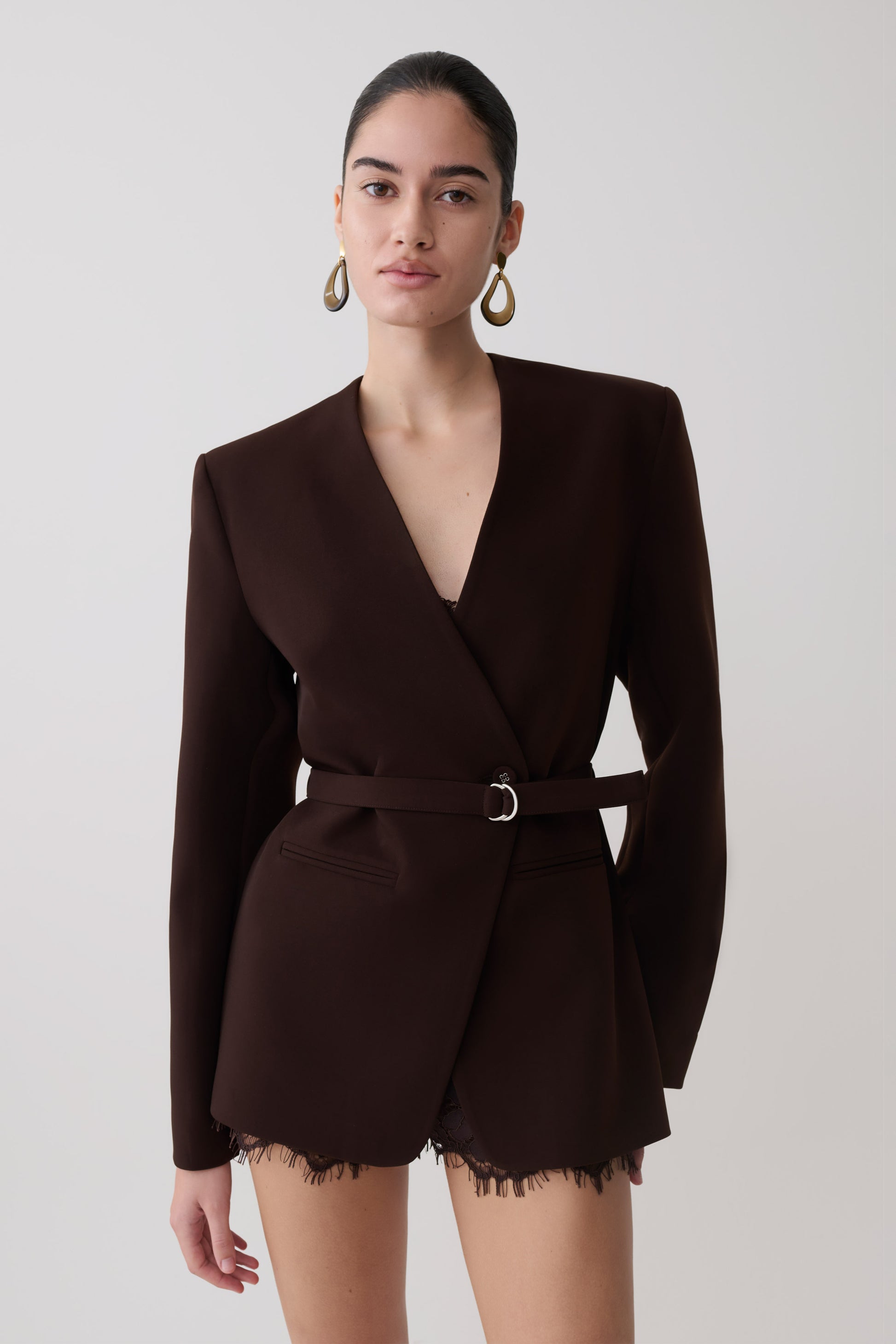 Woman wearing a dark brown drop shoulder suiting blazer.