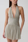 Womn wearing a silver halter pleated mini dress.