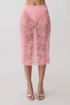Woman wearing a pink lace midi skirt.