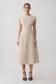 Woman wearing a beige linen cap sleeve midi dress.