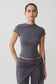 Woman wearing a grey high neck top with piping detail.
