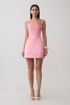 Woman wearing a pink satin corset mini dress.