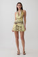 Woman wearing a yellow leopard print mesh halter mini dress.