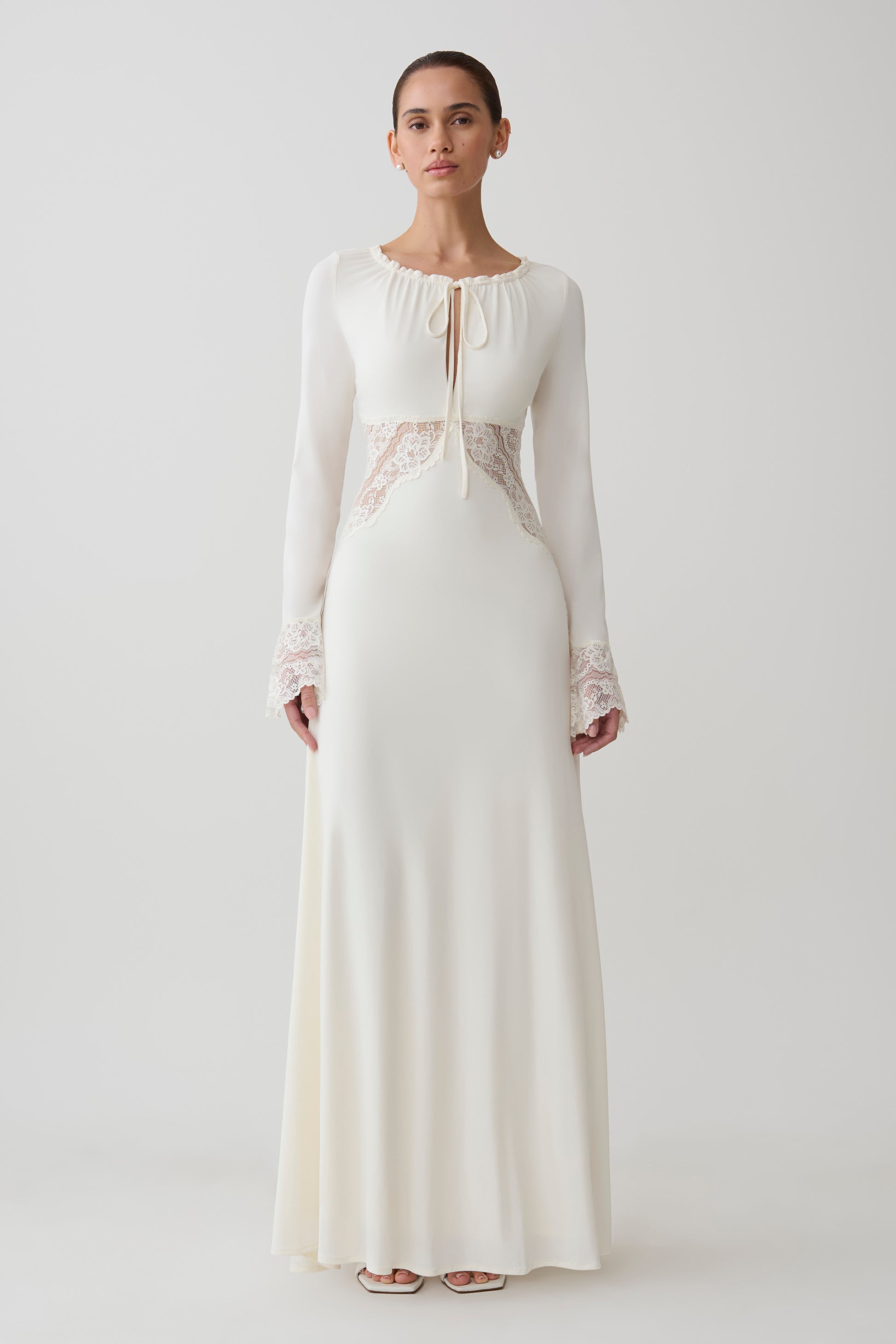 Woman wearing a white lace slinky maxi dress.