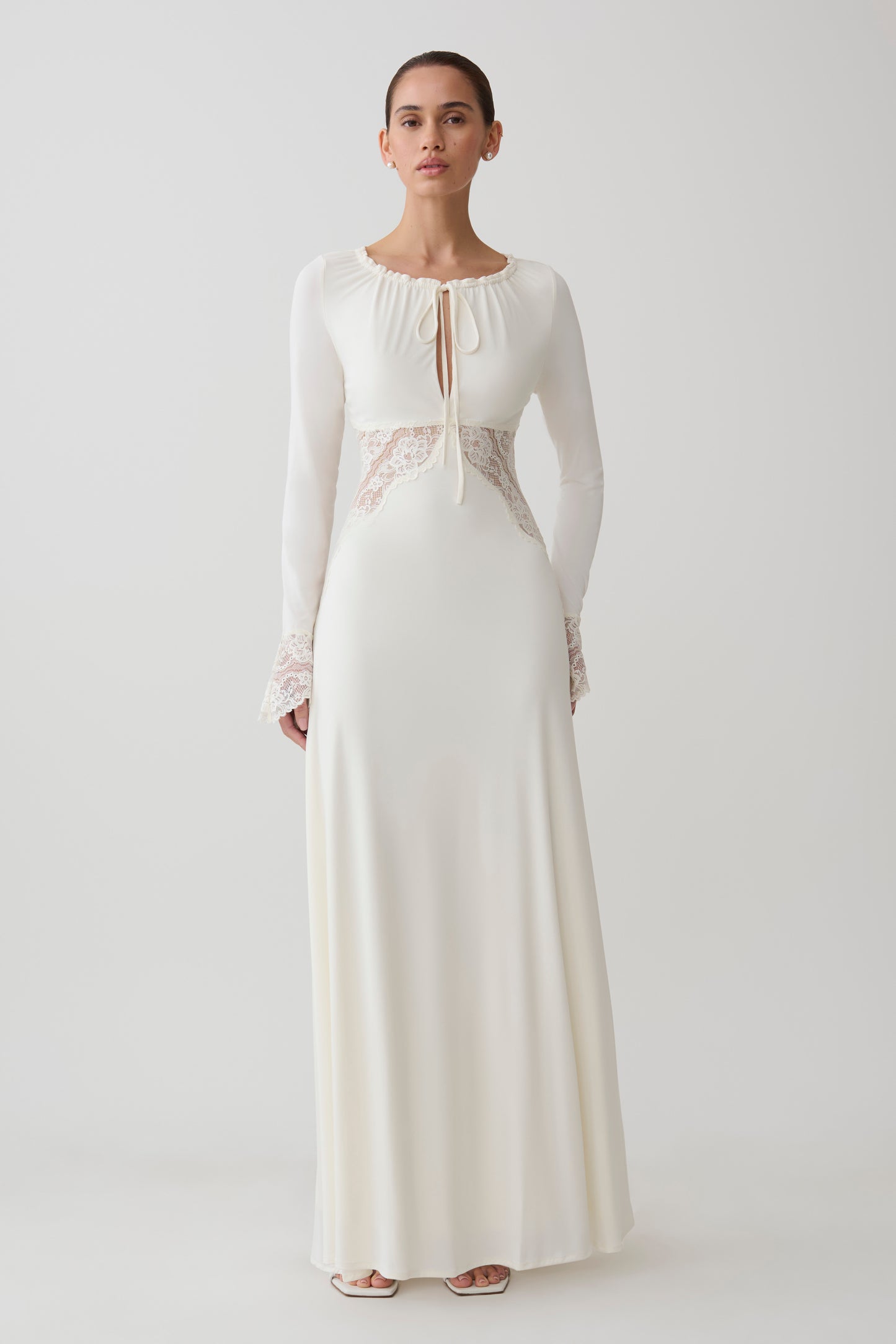 Woman wearing a white lace slinky maxi dress.