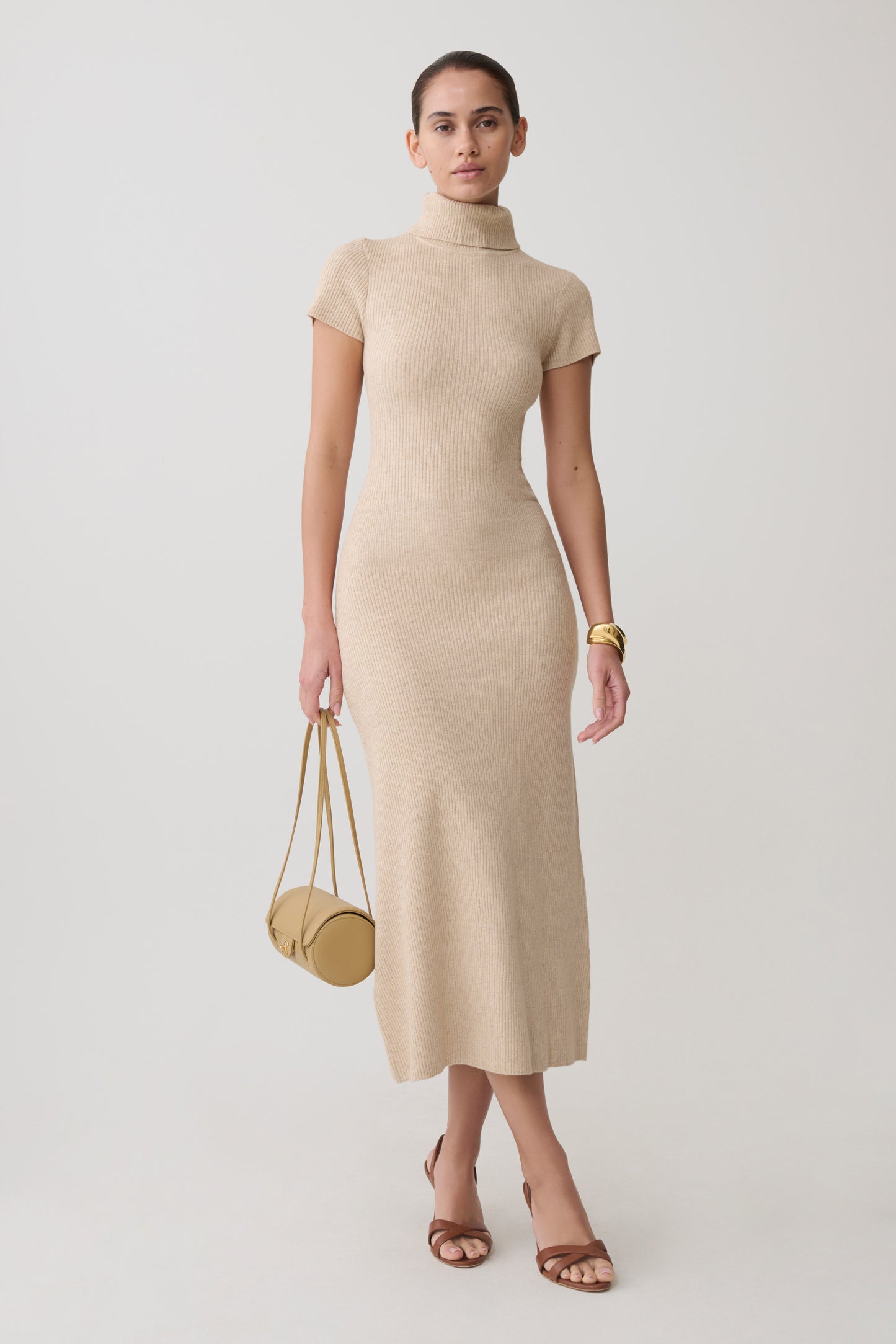 Woman wearing a beige high neck knit midi dress.
