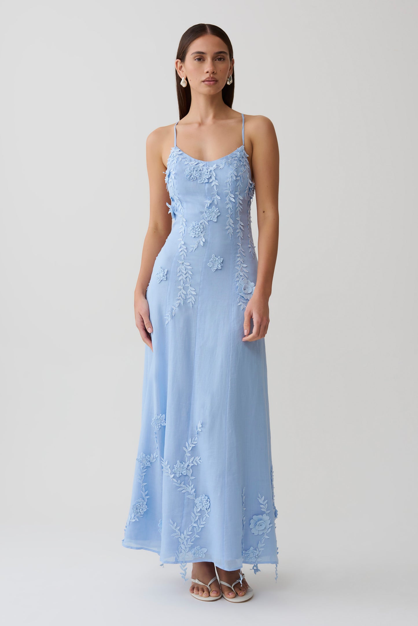 Woman wearing a blue floral lace midi dress.