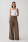 Woman wearing white tank with brown  wide leg suiting trouser.