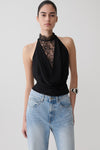 Woman wearing a black chiffon & lace halter top.