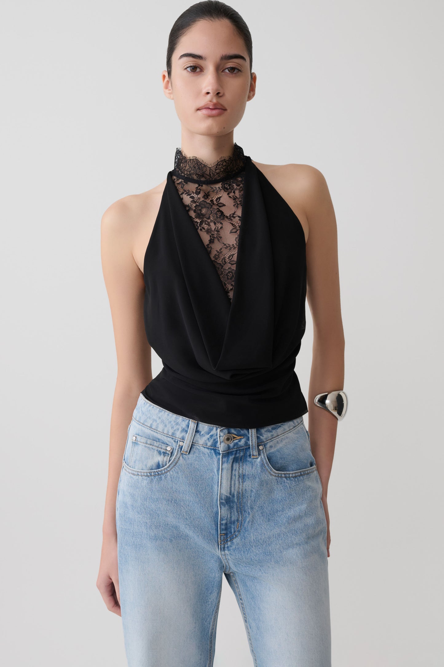 Woman wearing a black chiffon & lace halter top.
