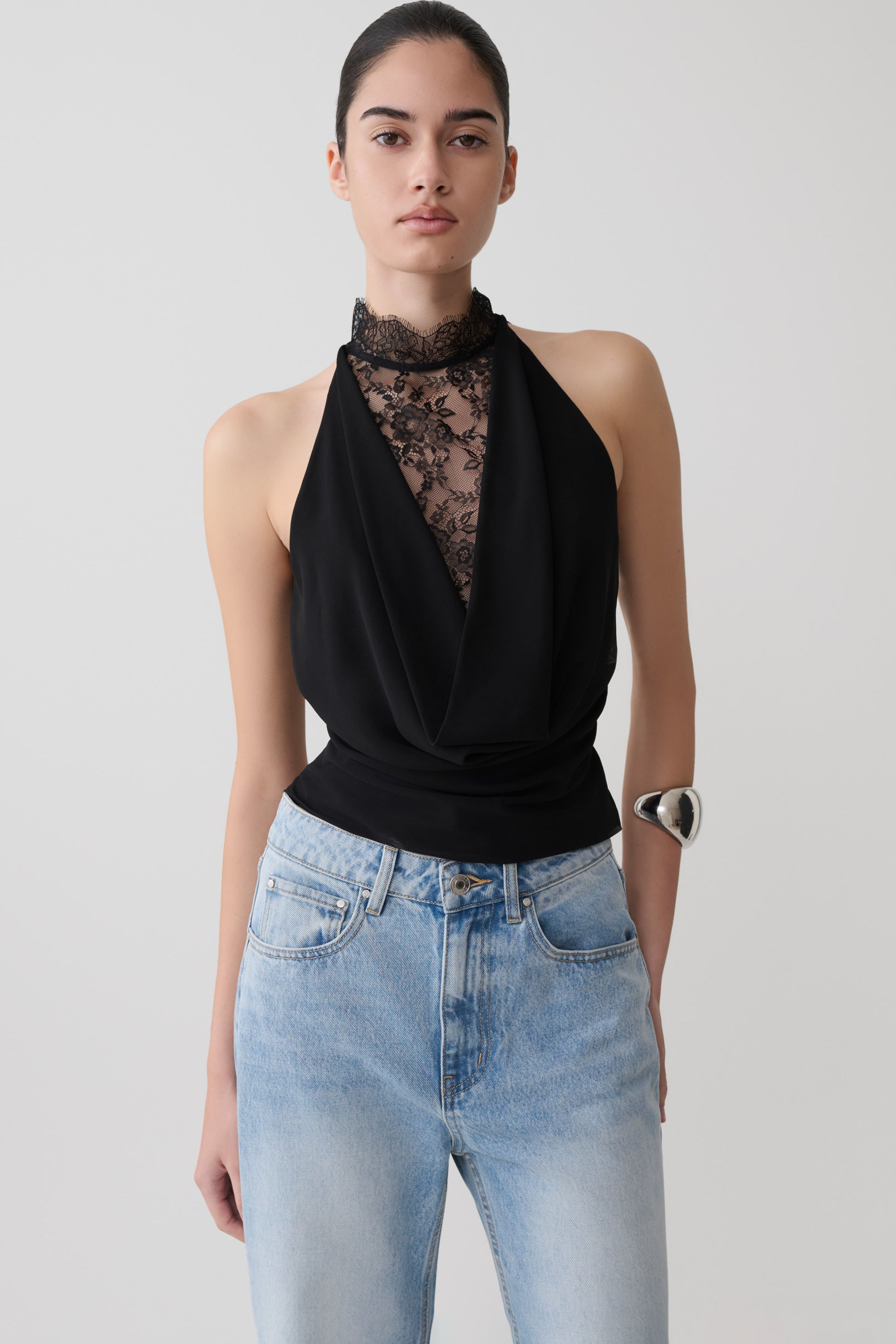 Woman wearing a black chiffon & lace halter top.