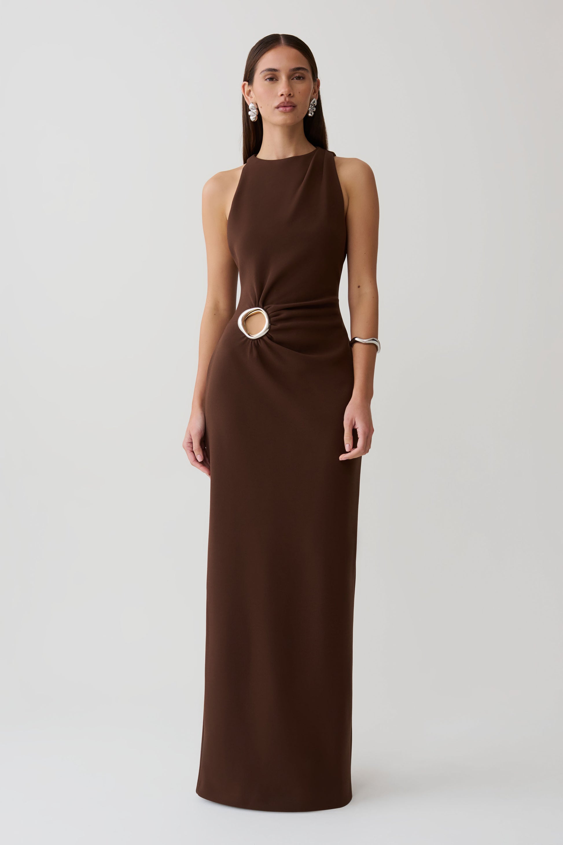 Woman wearing a brown maxi dress with silver hardware.