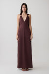 Woman wearing a brown draped shoulders satin maxi dress.