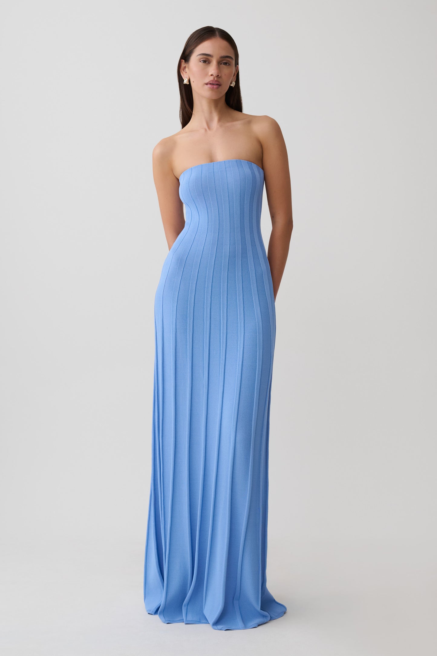 Woman wearing a blue ribbed strapless maxi dress.