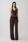 Woman wearing a brown slinky and mesh top with slinky gathered wide leg pants.