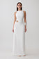 Woman wearing a white maxi dress wiith silver hardware.