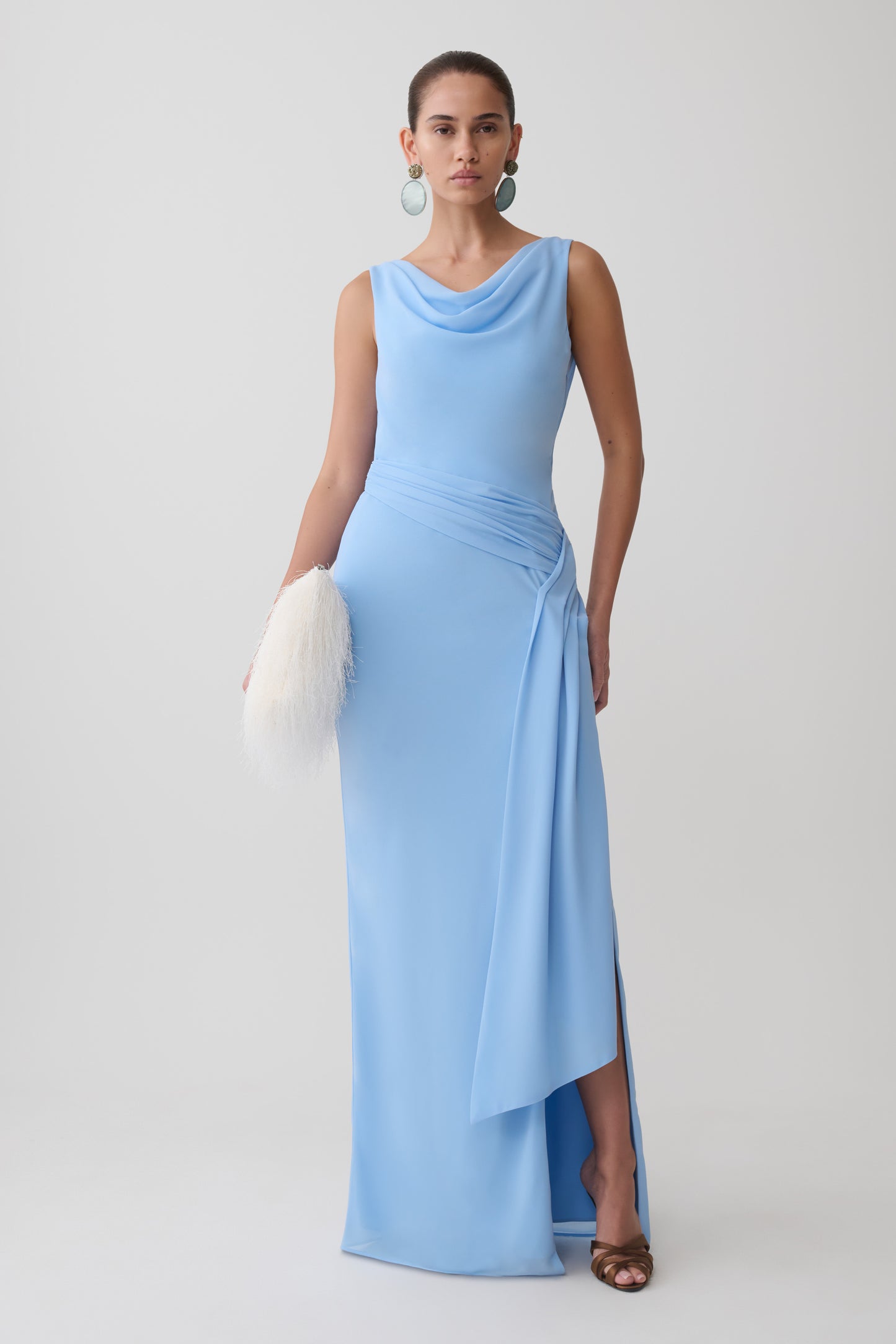 Woman wearing a light blue draped back chiffon maxi dress.