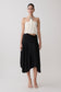 Woman wearing a white halter top and black slinky midi skirt. 