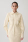 Woman wearing white faux leather shirt.