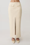 Woman wearing a white faux leather maxi skirt.