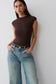 Woman wearing a brown peached jersey high neck top.