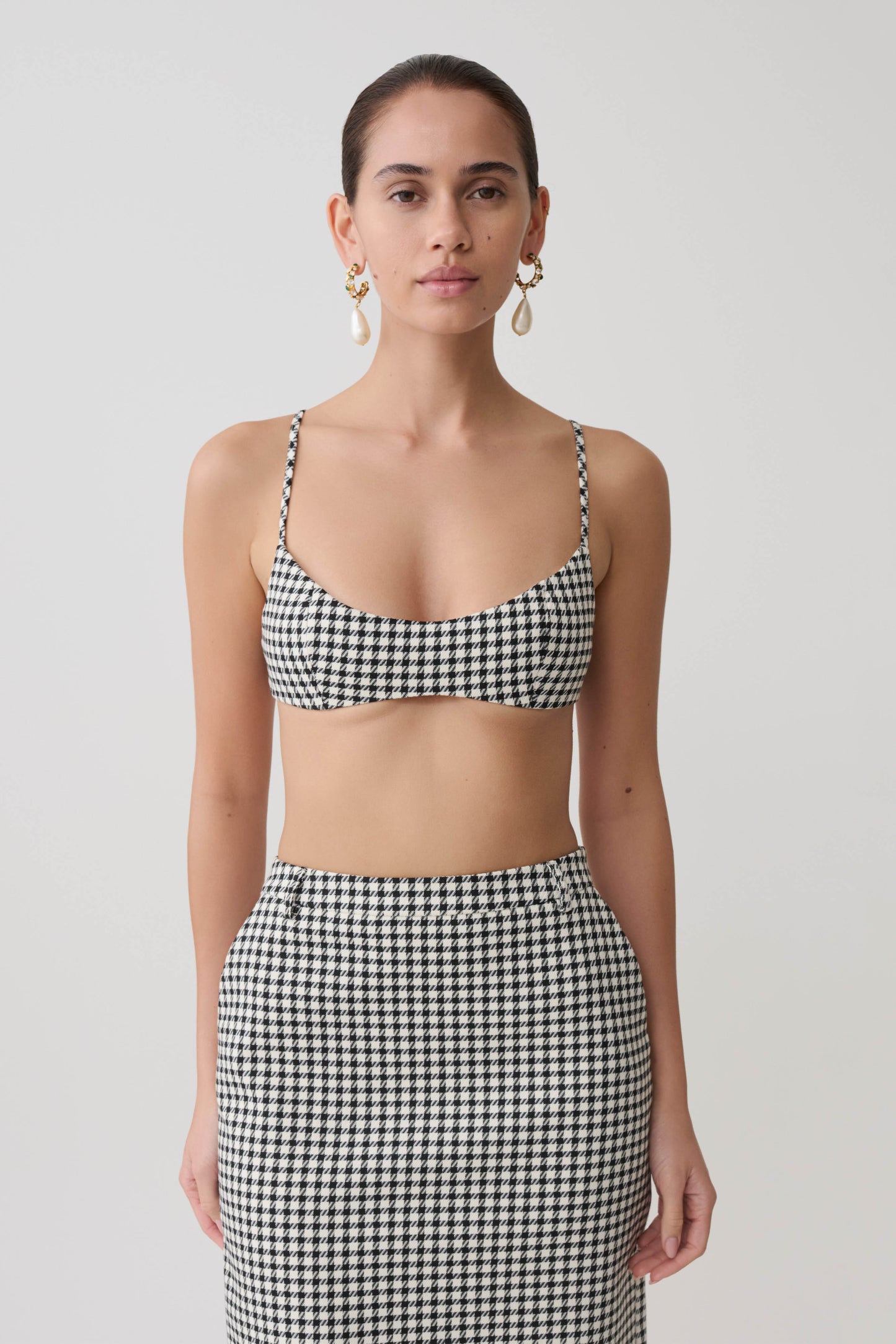 Woman wearing a black and white checkered tweed bralette.