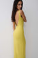 Woman wearing a green backless twist maxi dress.